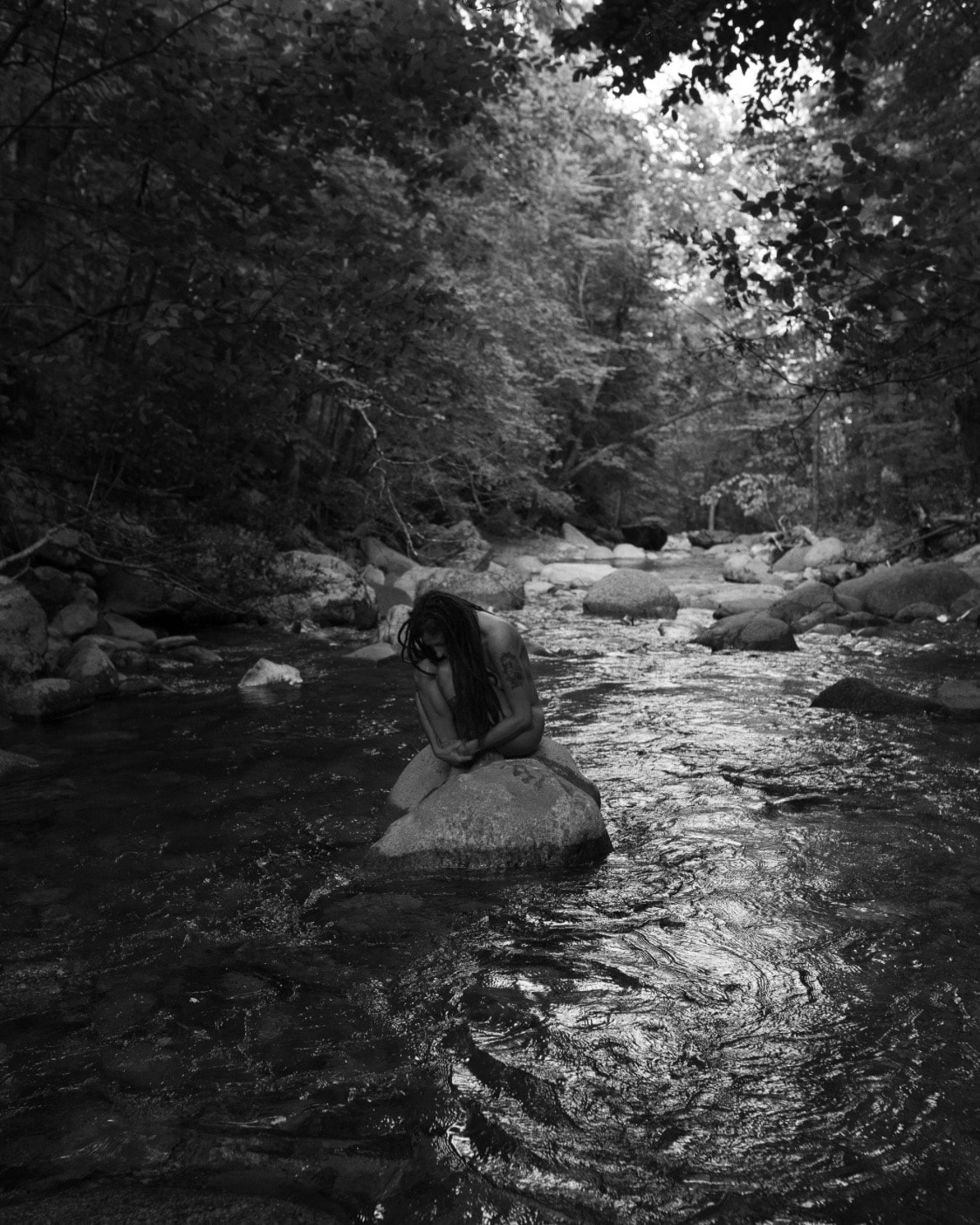 Figure seated on a rock in a forest stream — Christopher Thomas's interpretation of the poem 'Home'